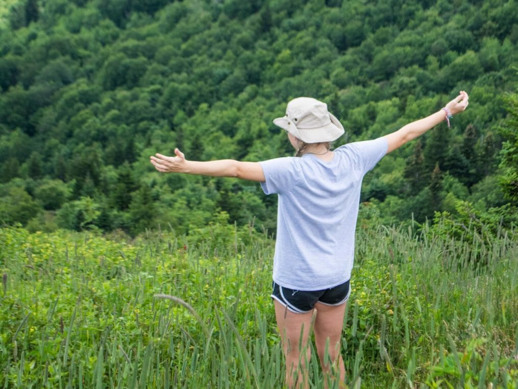 Camper with arms wide open by mountains at the Hendersonville Adventure Day Camp