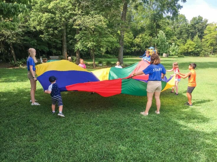 Campers playing with a parachute at Local Church Day Camps