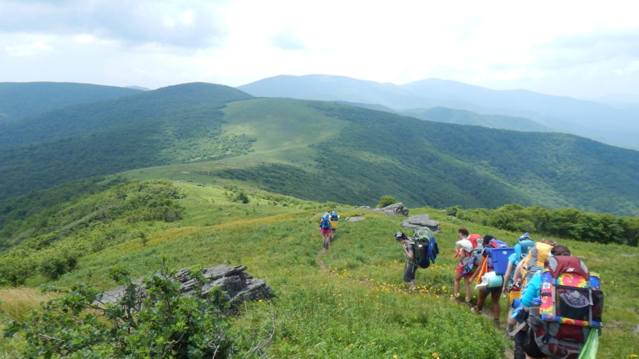 Campers Hiking on a Hill.